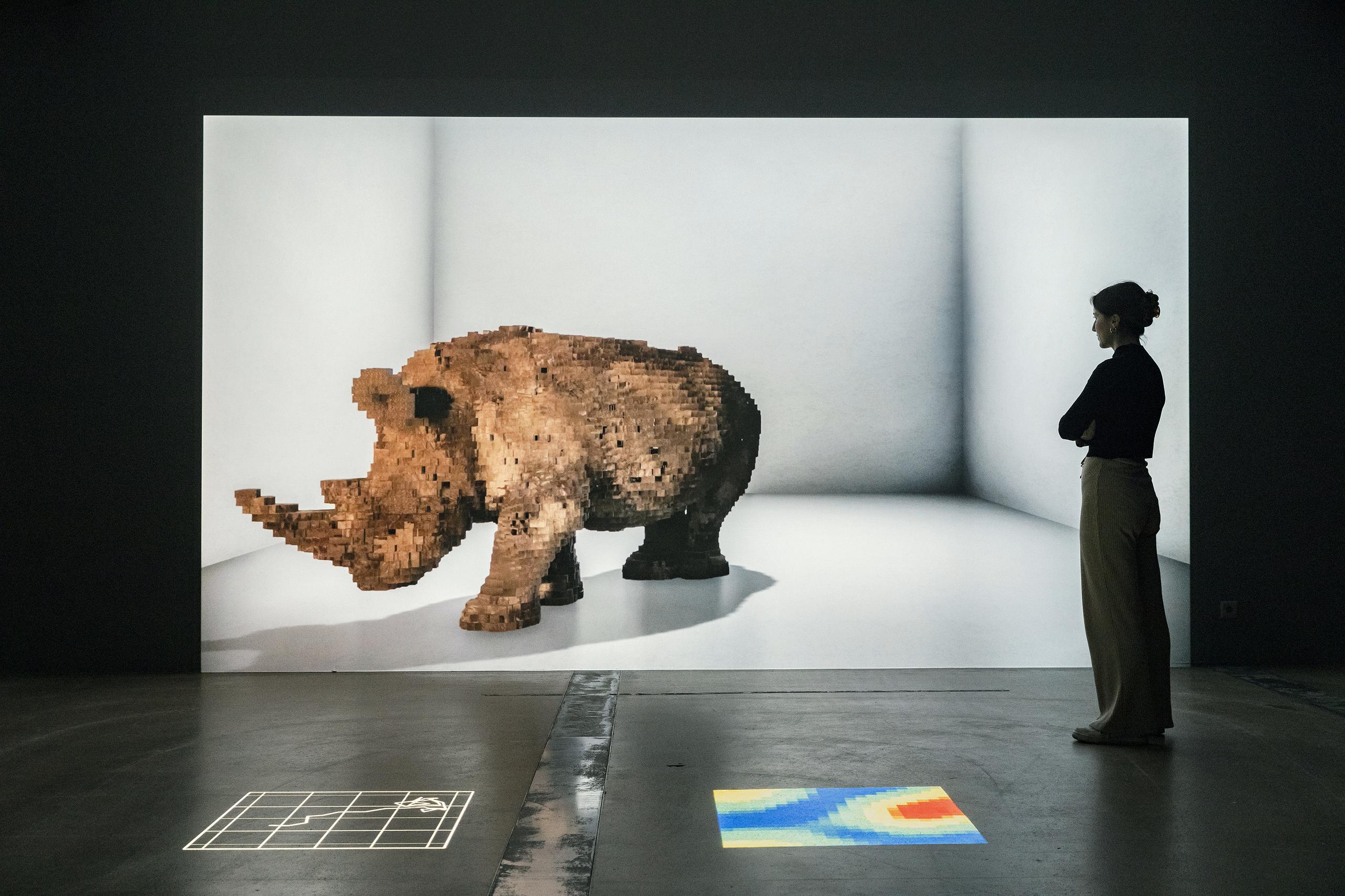Ein lebensgrosses Nashorn wird in den Ausstellungsraum projiziert 